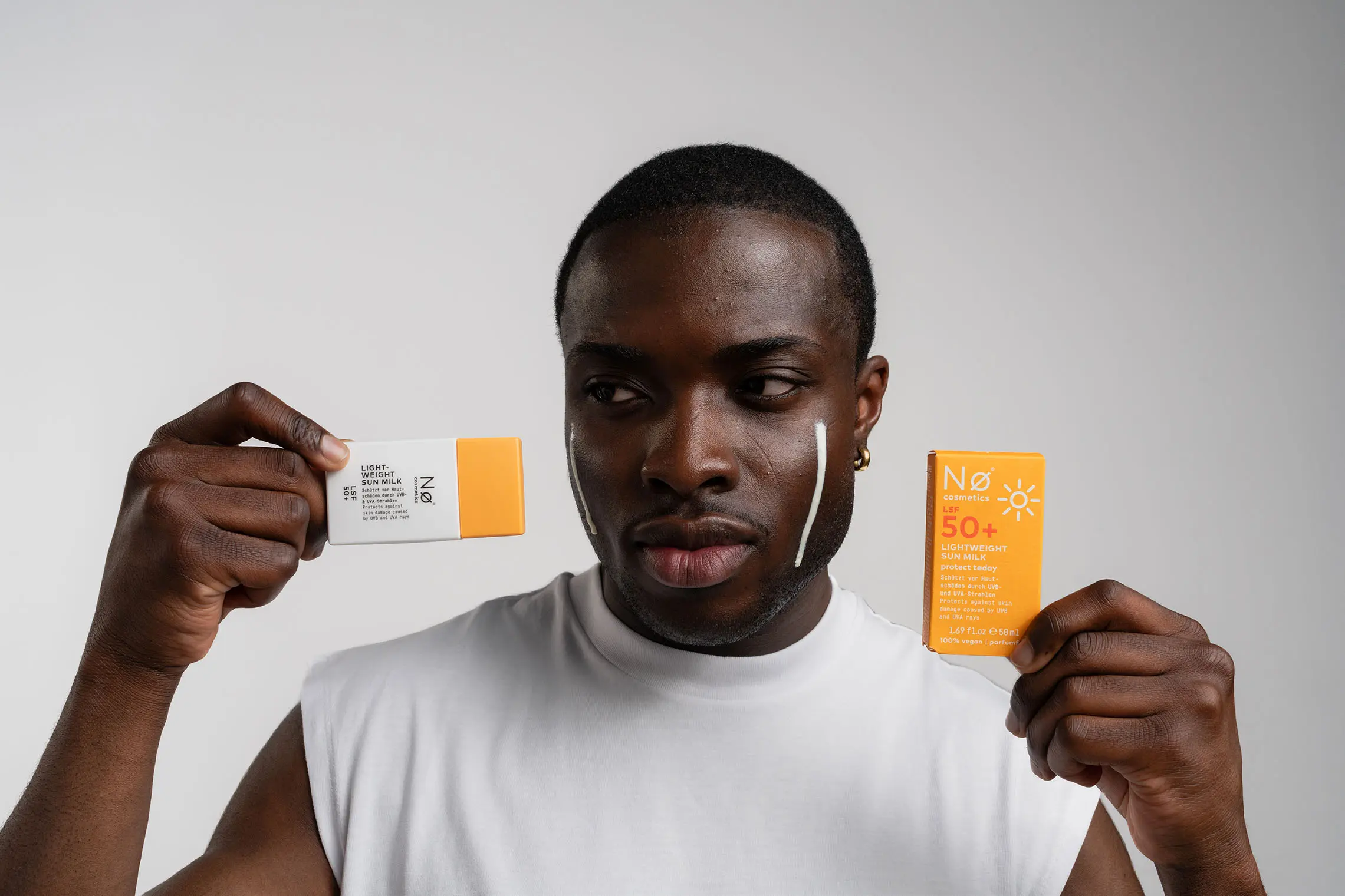 Person mit der Lightweight Sun Milk von Nø Cosmetics