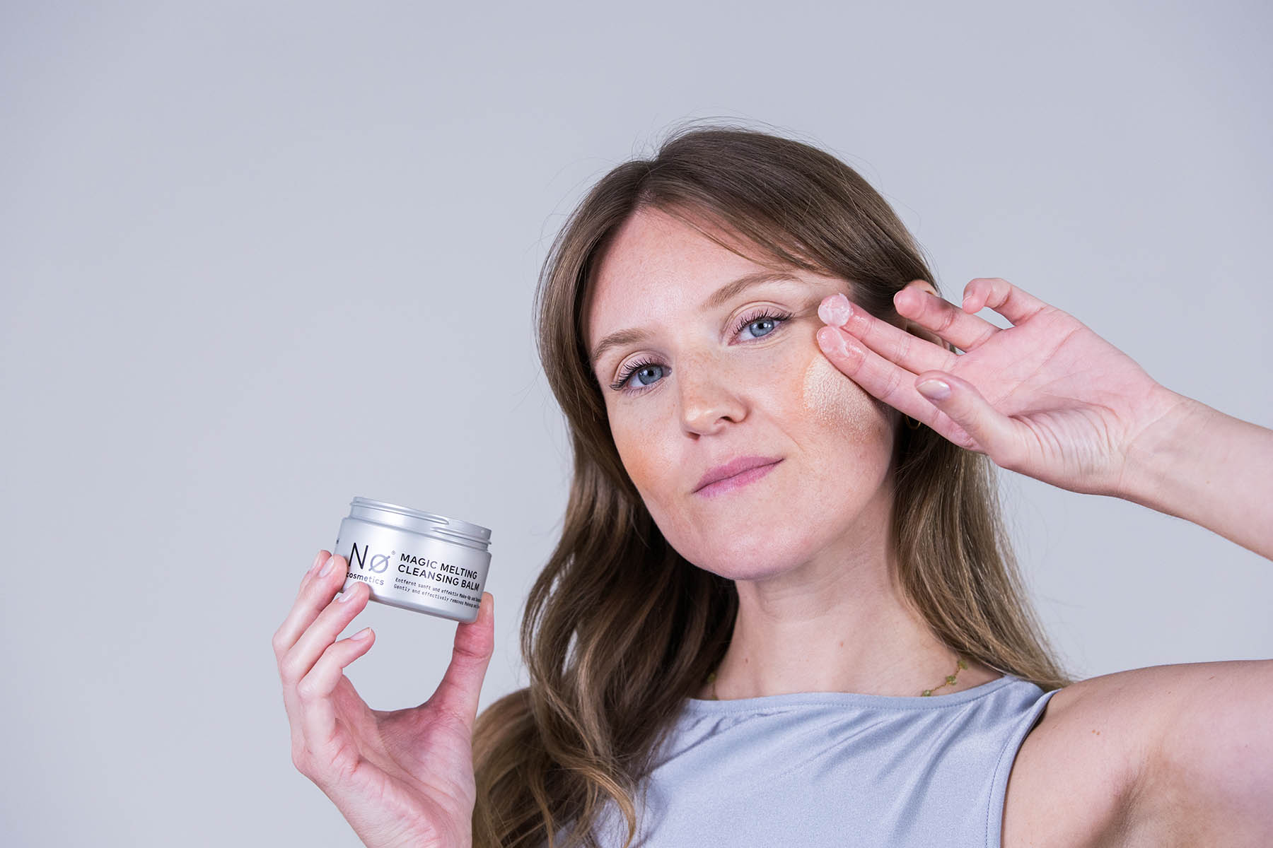 Person massiert Magic Melting Cleansing Balm in das Gesicht ein
