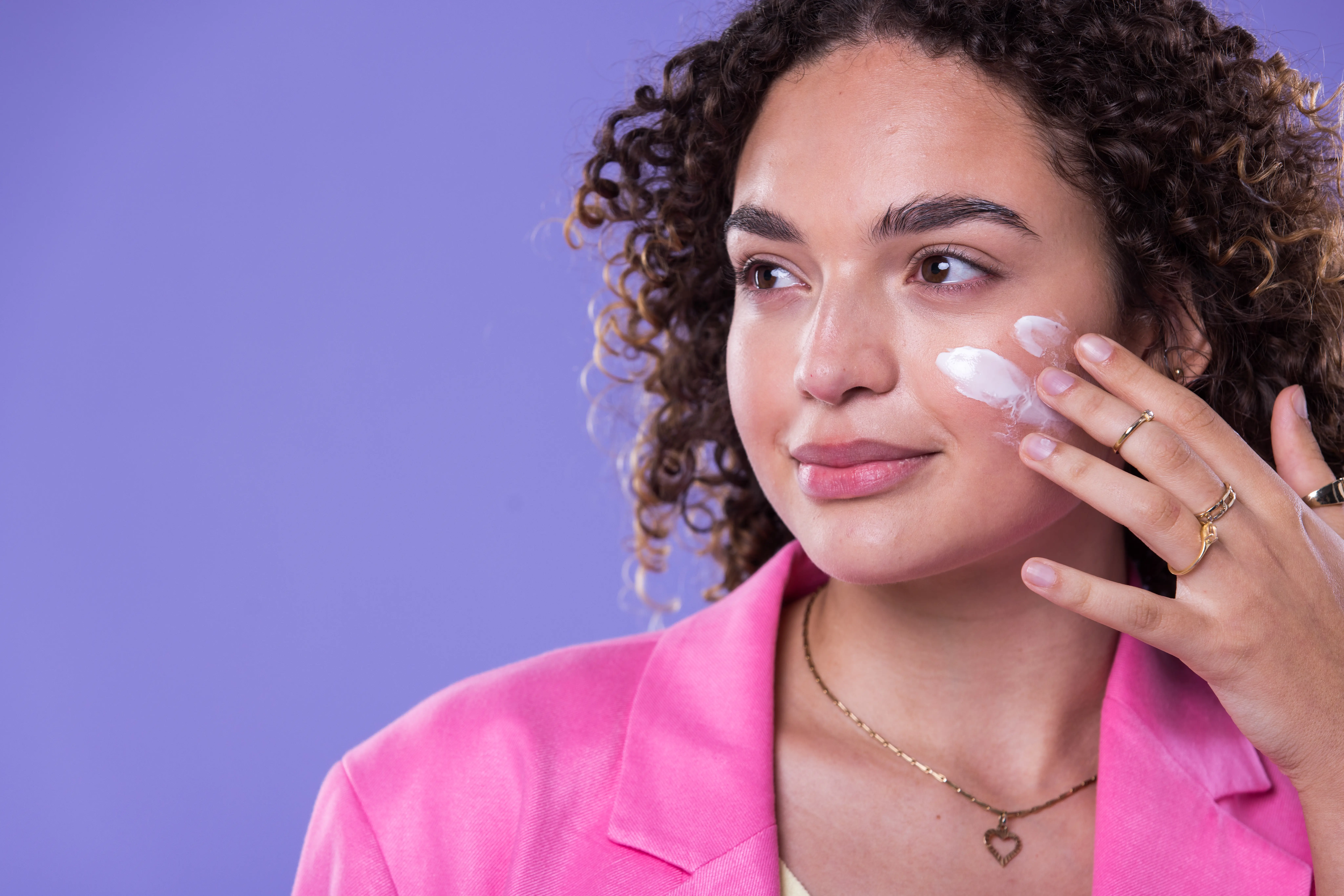 Person trägt Gesichtscreme auf die Wange auf