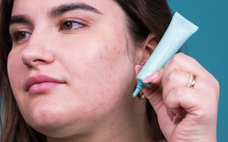 Person trägt das Invisible Spot Treatment auf Unreinheiten im Gesicht auf