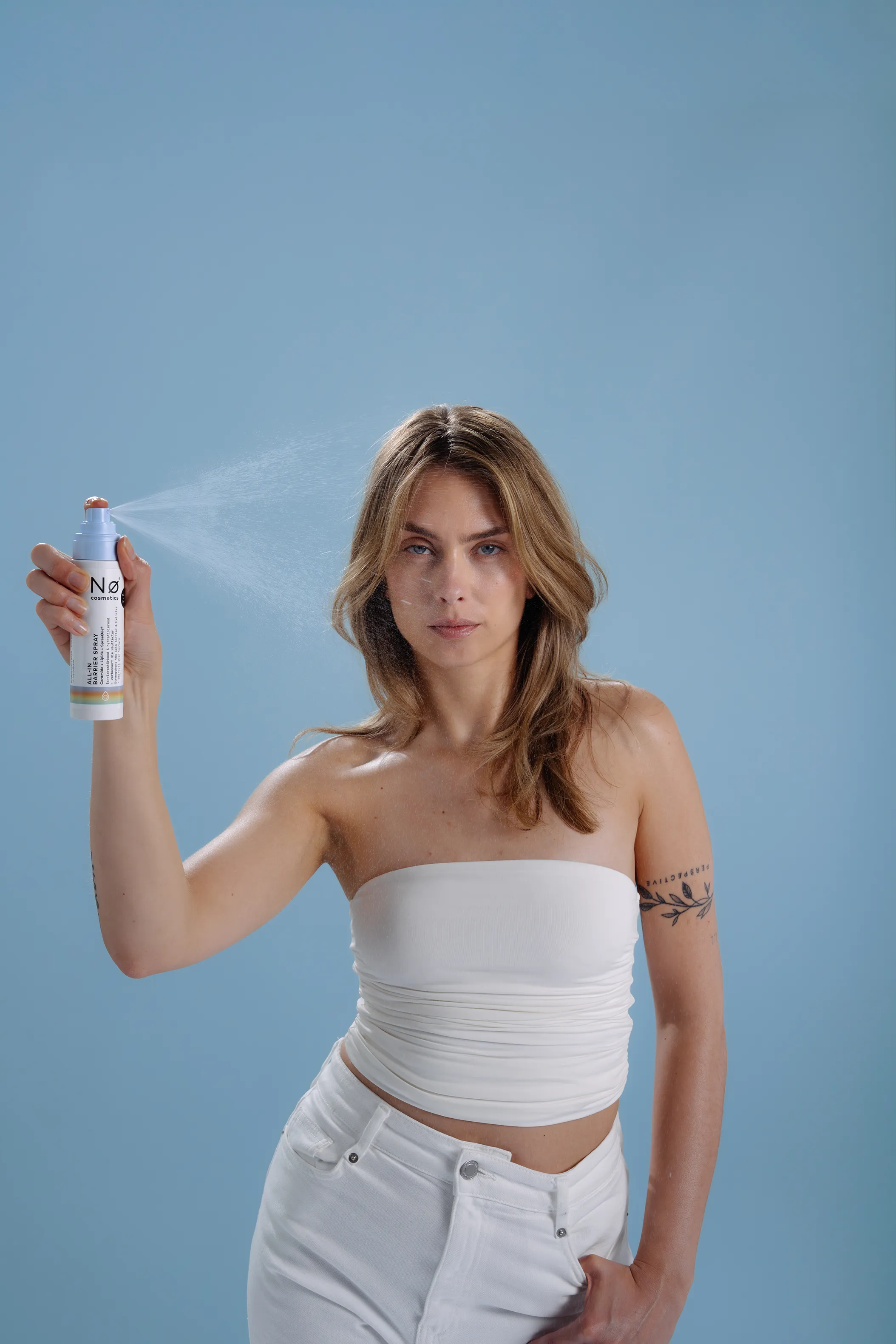 Person sprüht das pflegende Gesichtsspray cheer tøday von Nø Cosmetics